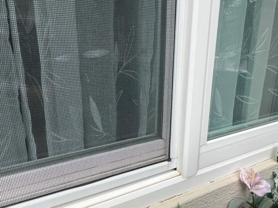 Close-up of a clean window screen and track after professional window cleaning